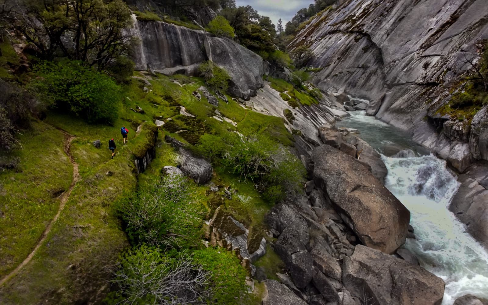 Two hikers on a trail above the granite-walled Cosumnes River Gorge near Plymouth, California